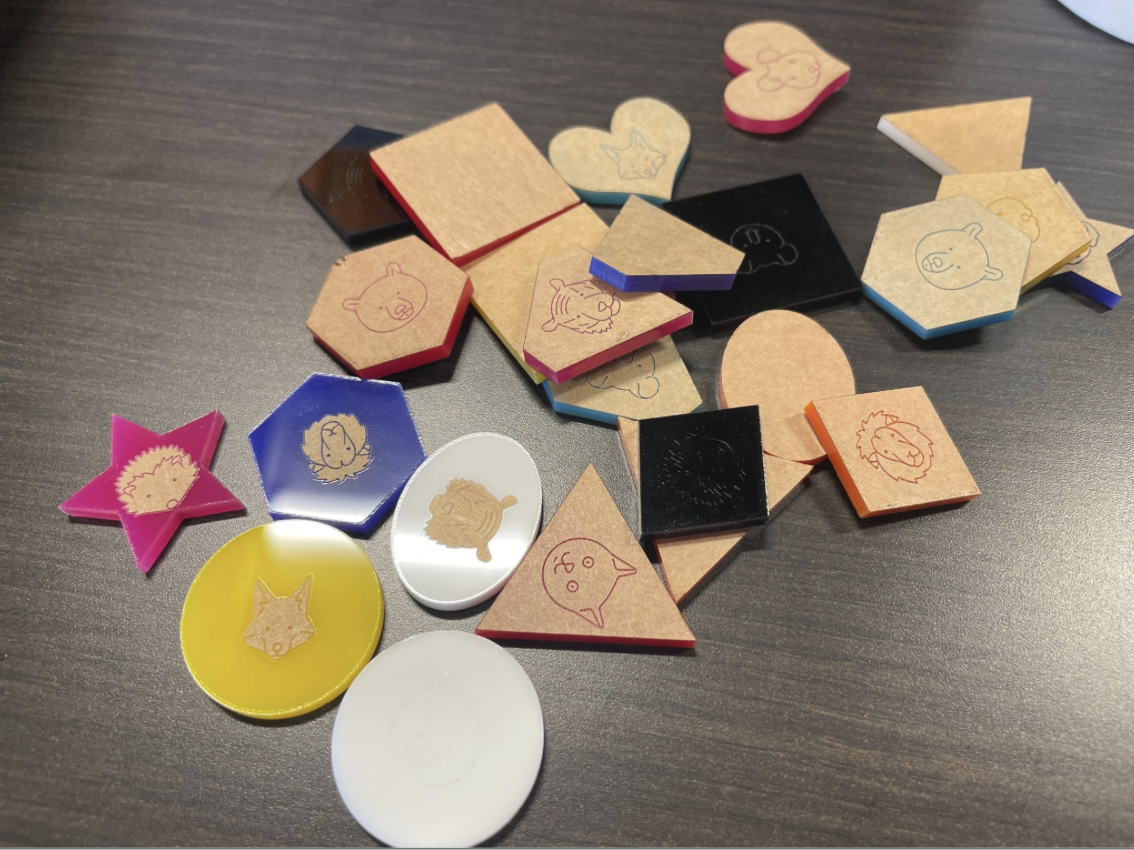 A pile of tokens of various sizes and colours, with the outlines of animals printed on them